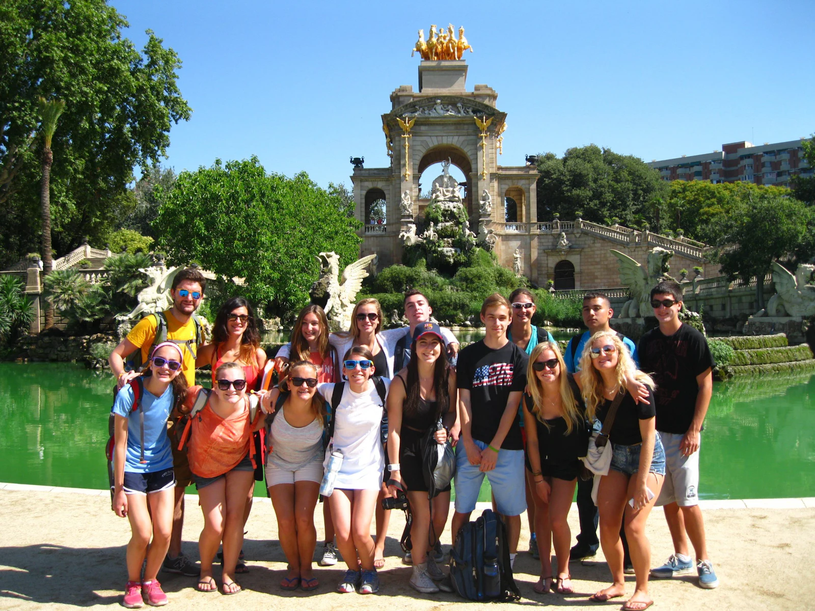 A group of teen travelers stands in front of the Cascada fountain in Barcelona's Parc de la Ciutadella, Spain