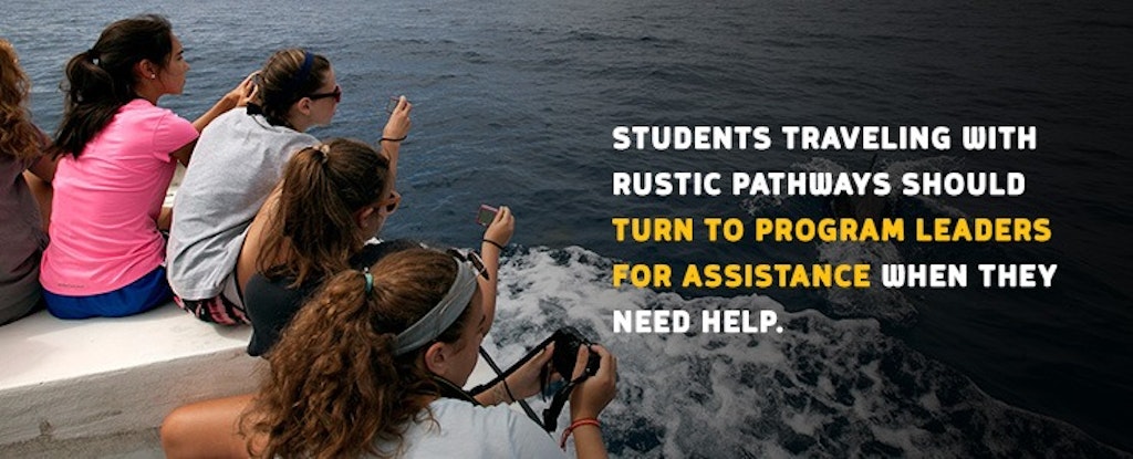 Students taking photos of the ocean on a Rustic Pathways travel program