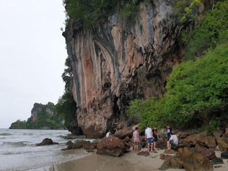 Students on a beach near a cliffside in Southern Thailand