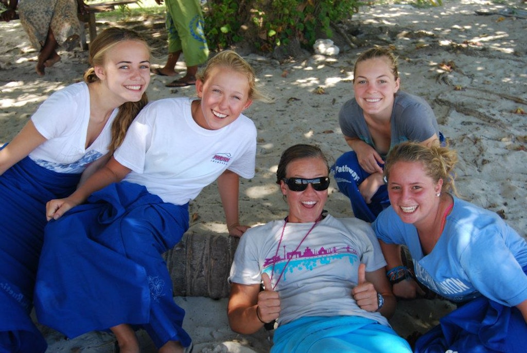 Five students pose for the camera at a beach location.
