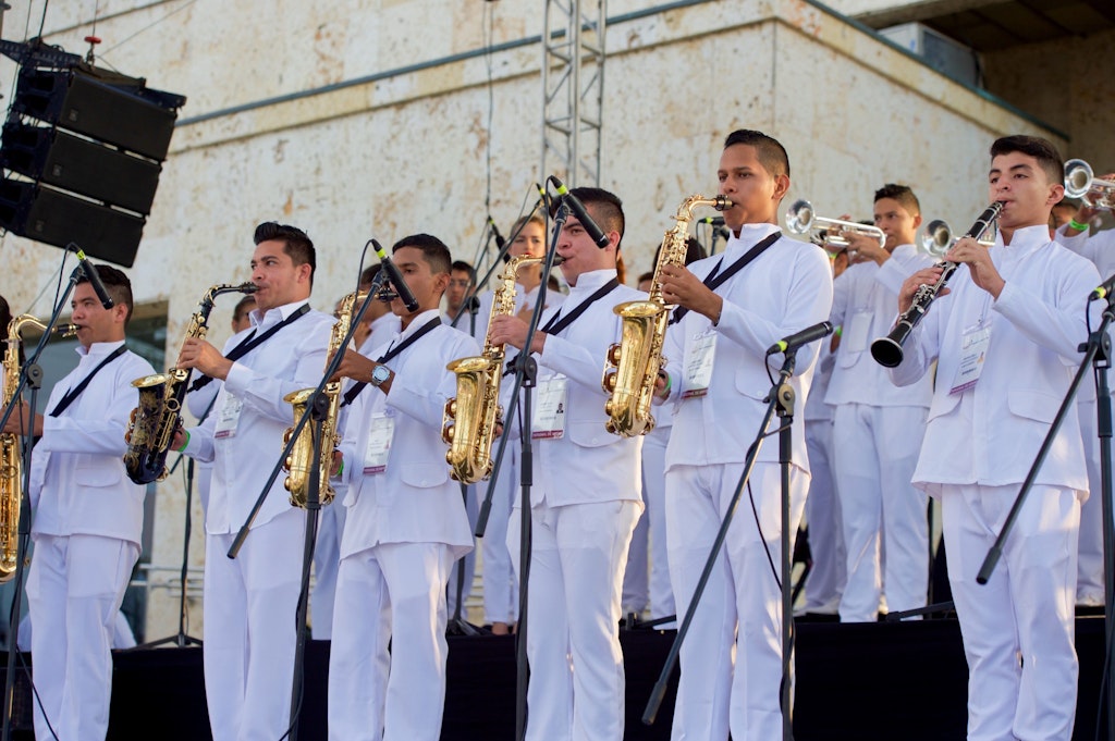 Colombians playing the National Anthem of Colombia with instruments on a stage