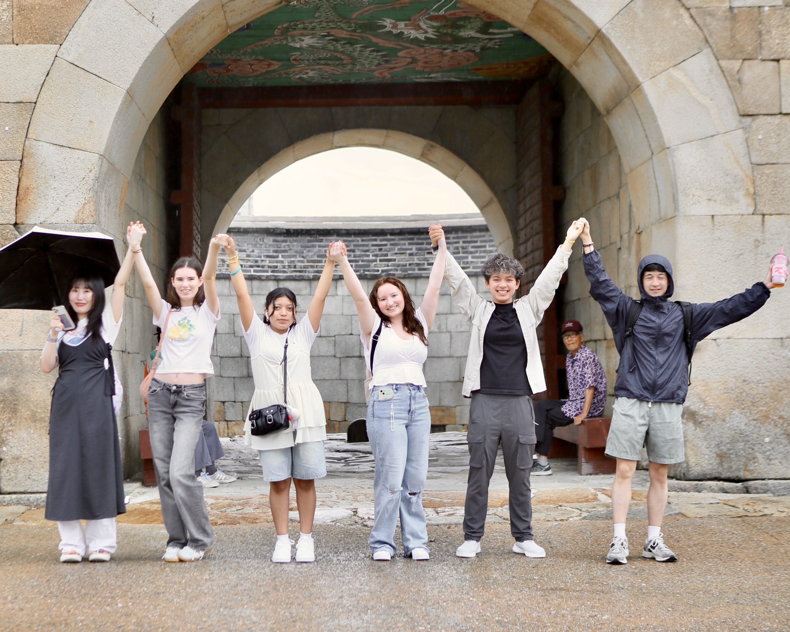 Students and program leaders posing for a photo infront of a palace gate in South Korea on a student travel program.