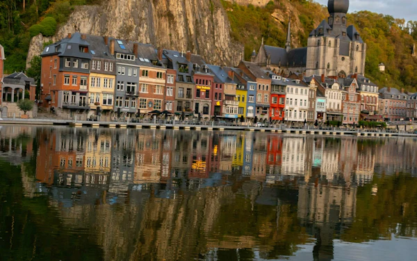 A rocky bluff topped by a citadel above a church dome, reflected in the river below.