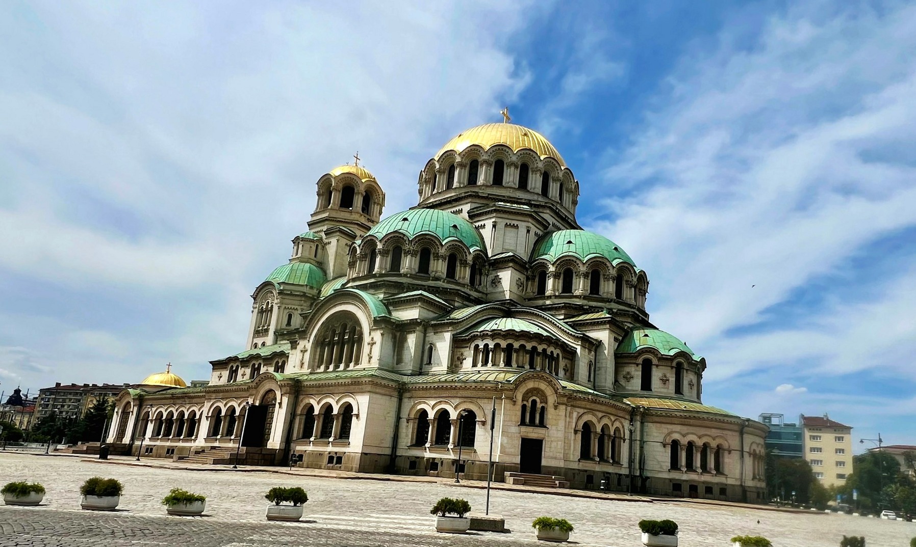 Alexander Nevsky Cathedral in Sofia, its gold and green domes above the paved square in front of it.
