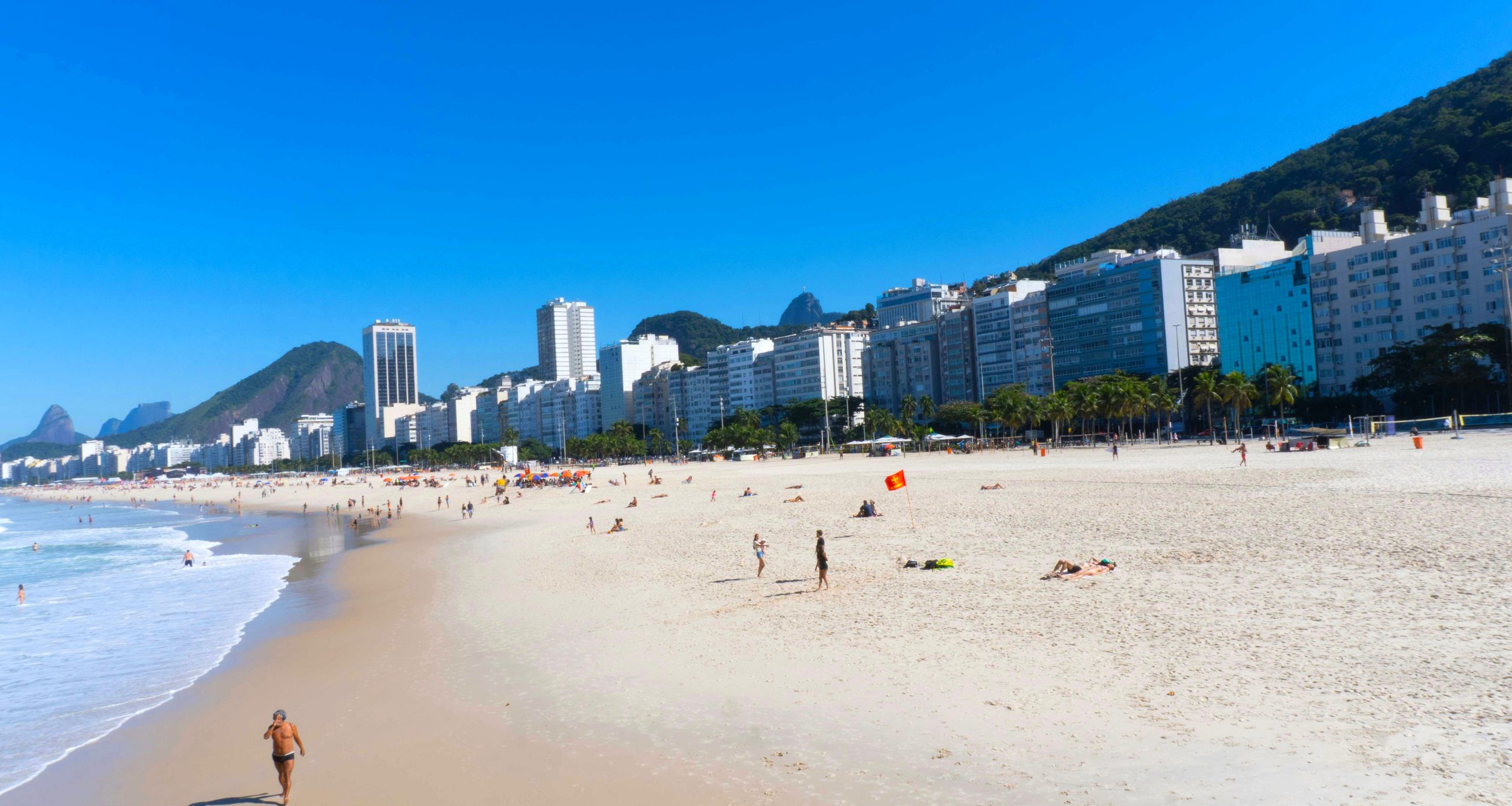 The curve of Copacabana beach with its line of apartment blocks and the forested hills behind them.