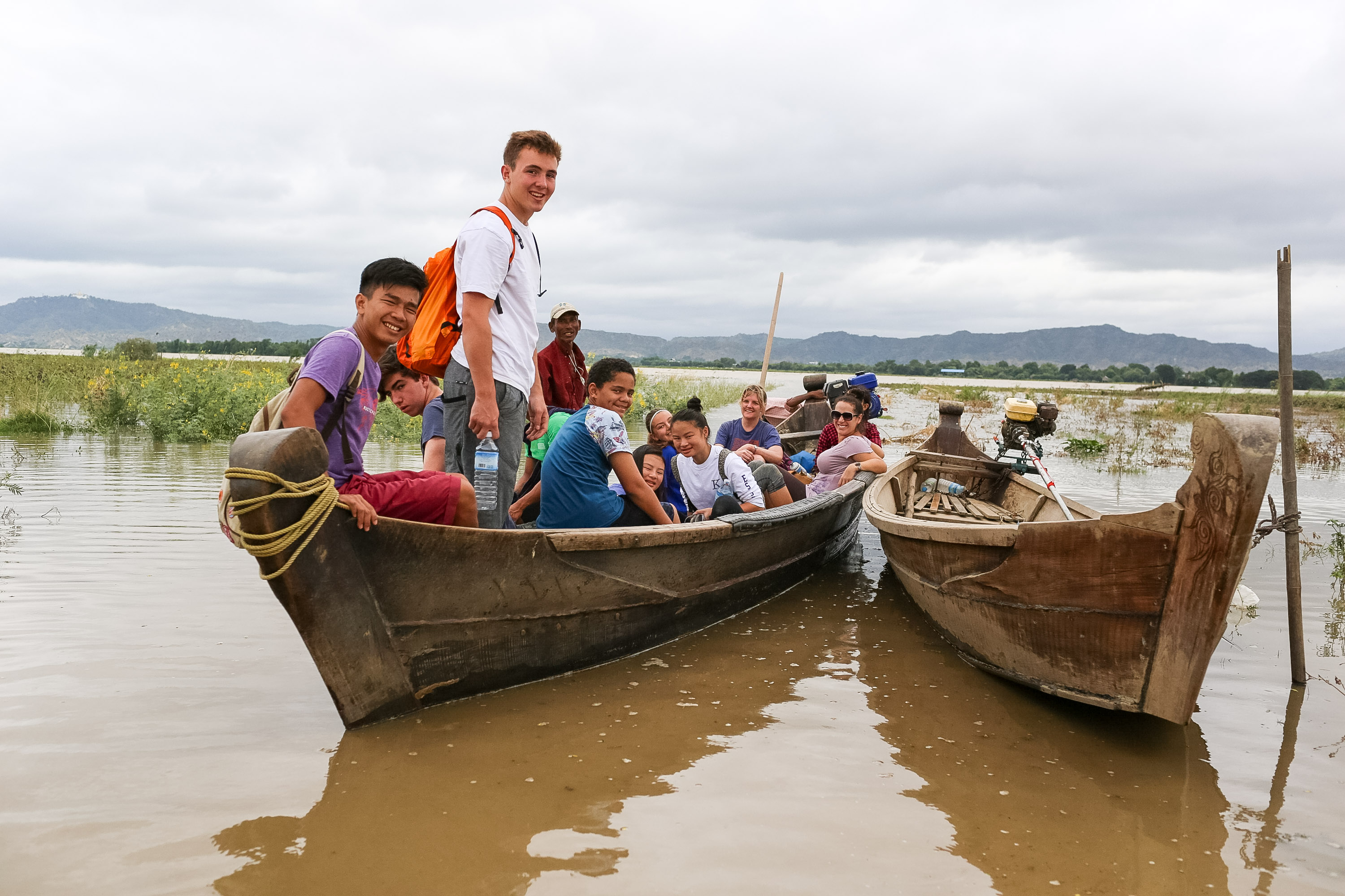 Students and local boat drivers ride wooden boats across Inle Lake