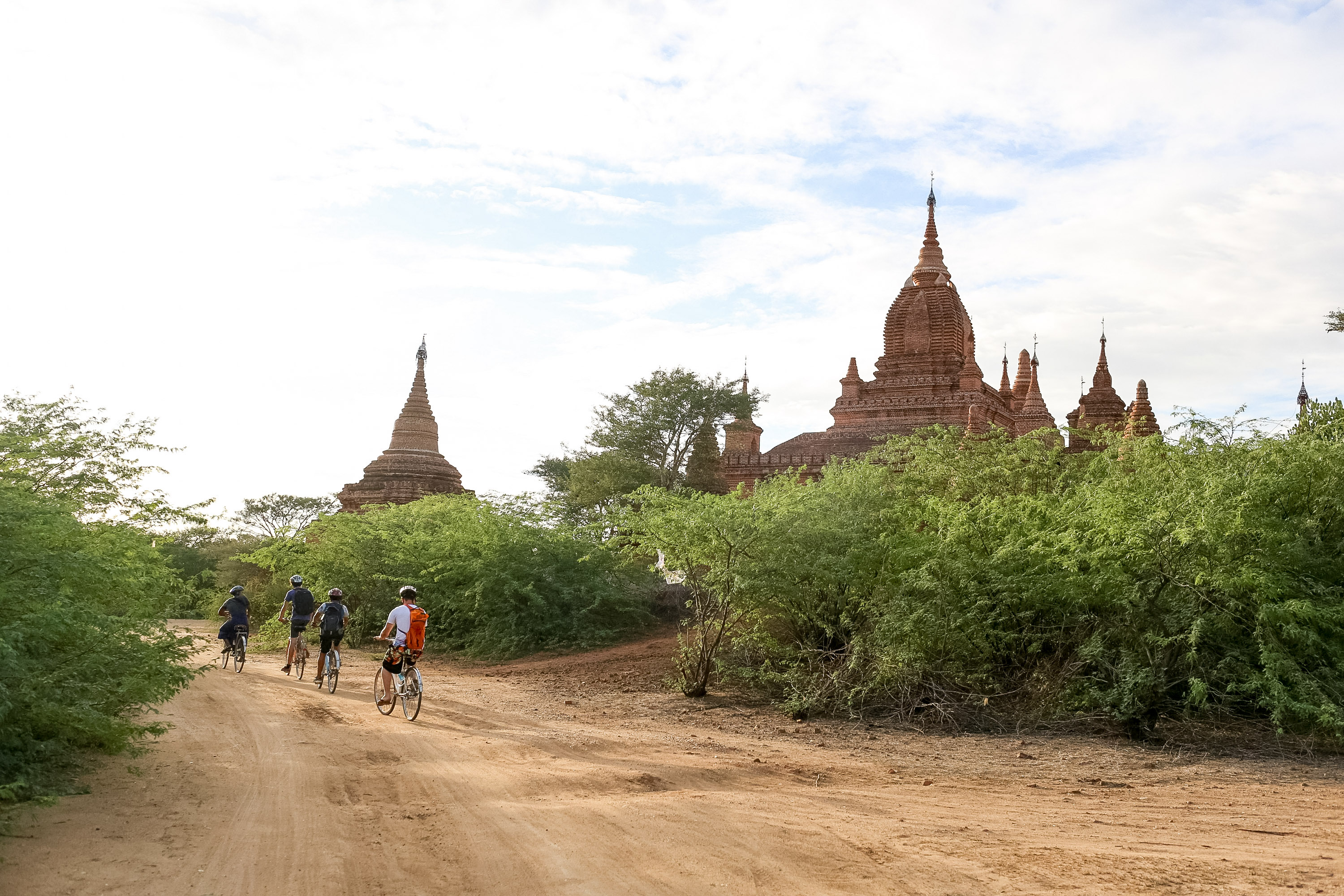 Students bike a dirt road past ancient temples in Bagan in Myanmar
