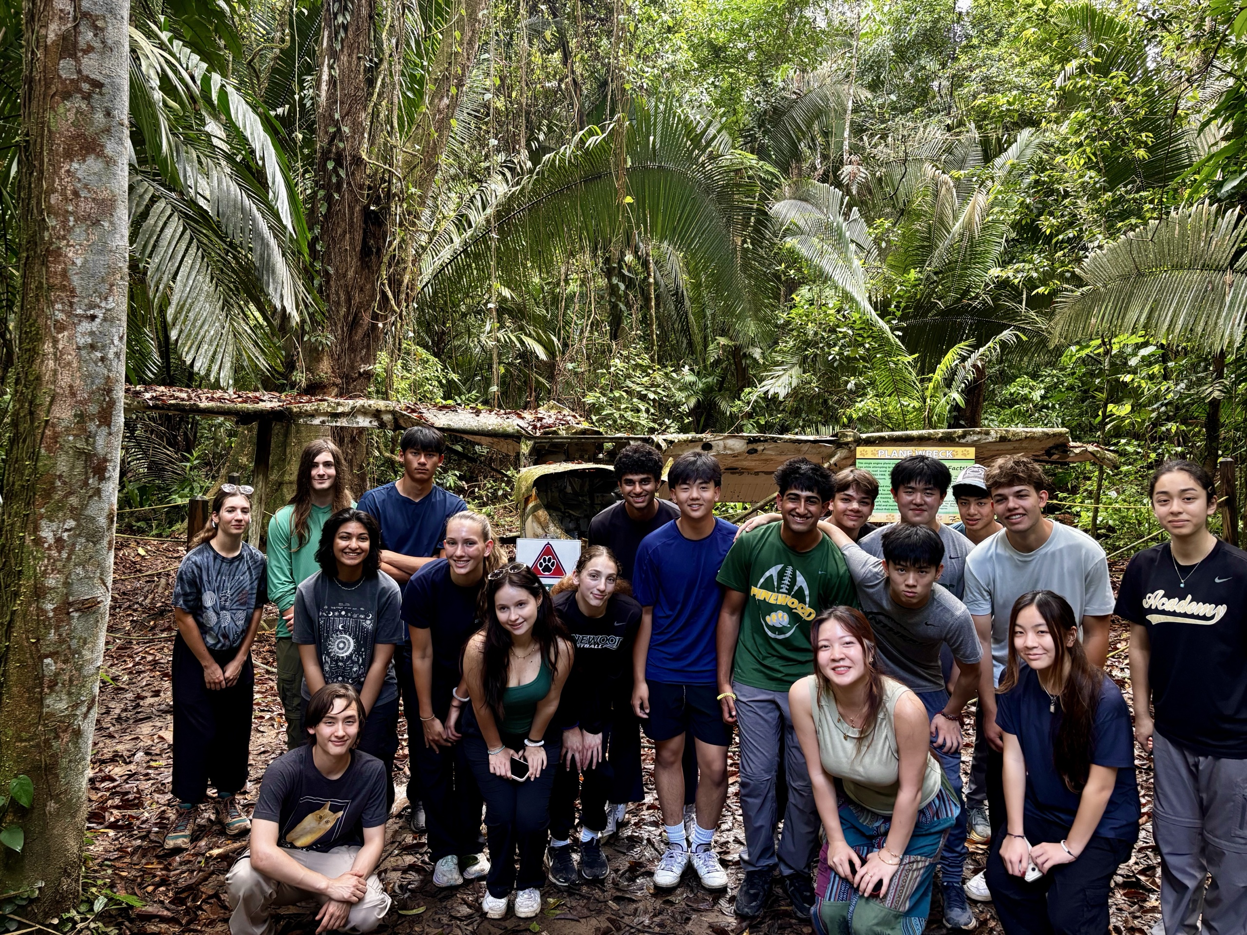 Students gather beside an old plane wreck on a rainforest trail at Cockscomb Basin Wildlife Sanctuary