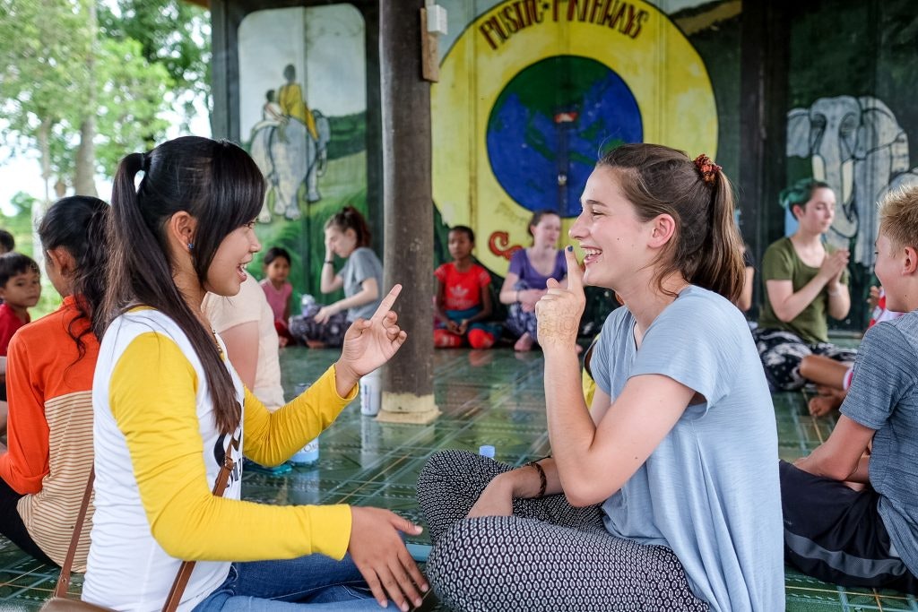 Teens interacting with local students on a service learning trip