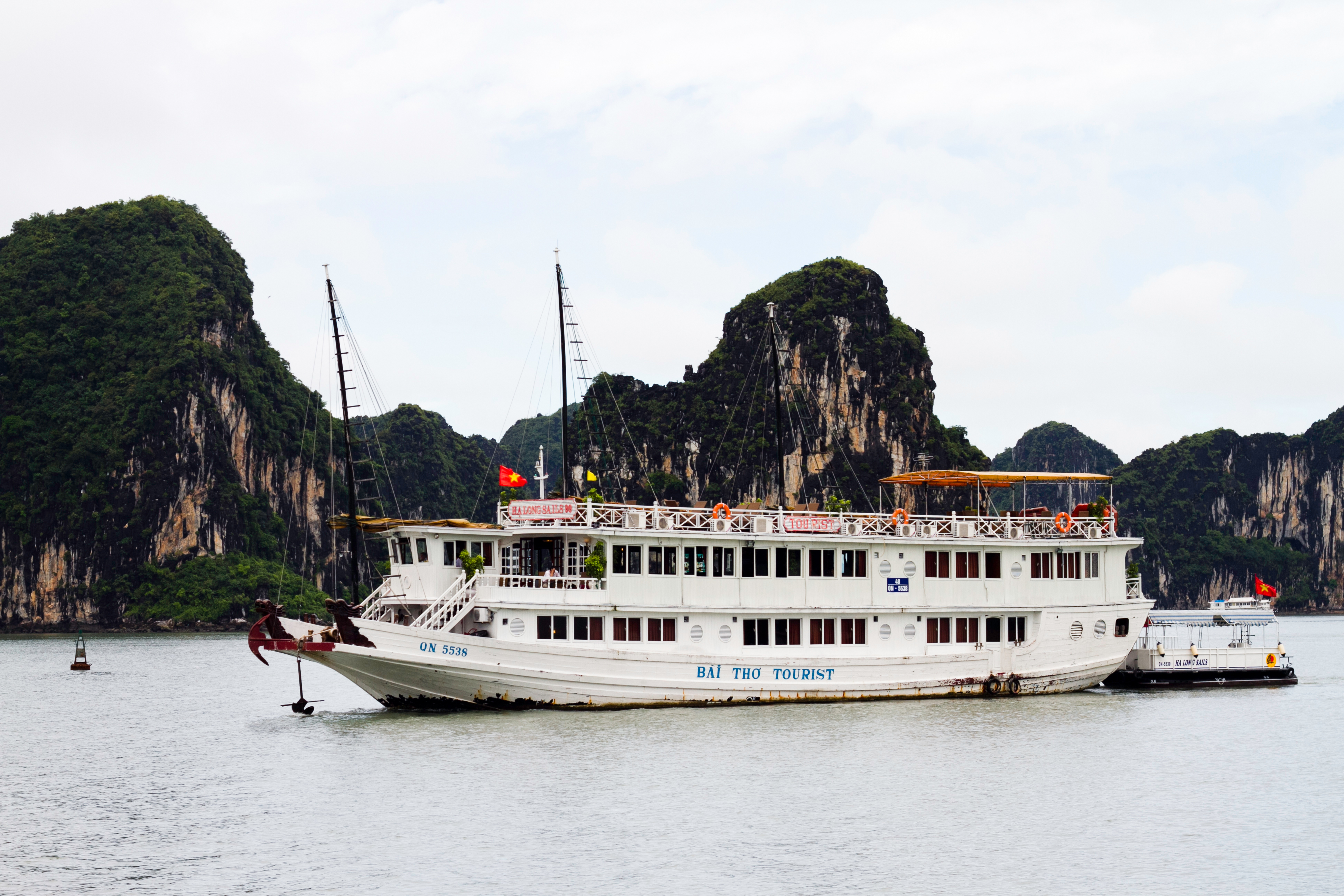 A tour boat anchored among the limestone karsts of Ha Long Bay