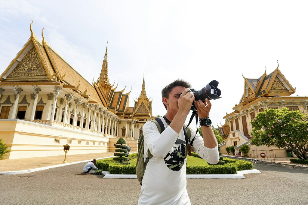 Family volunteer abroad programs student capturing cultural architecture on camera while exploring heritage landmarks abroad.