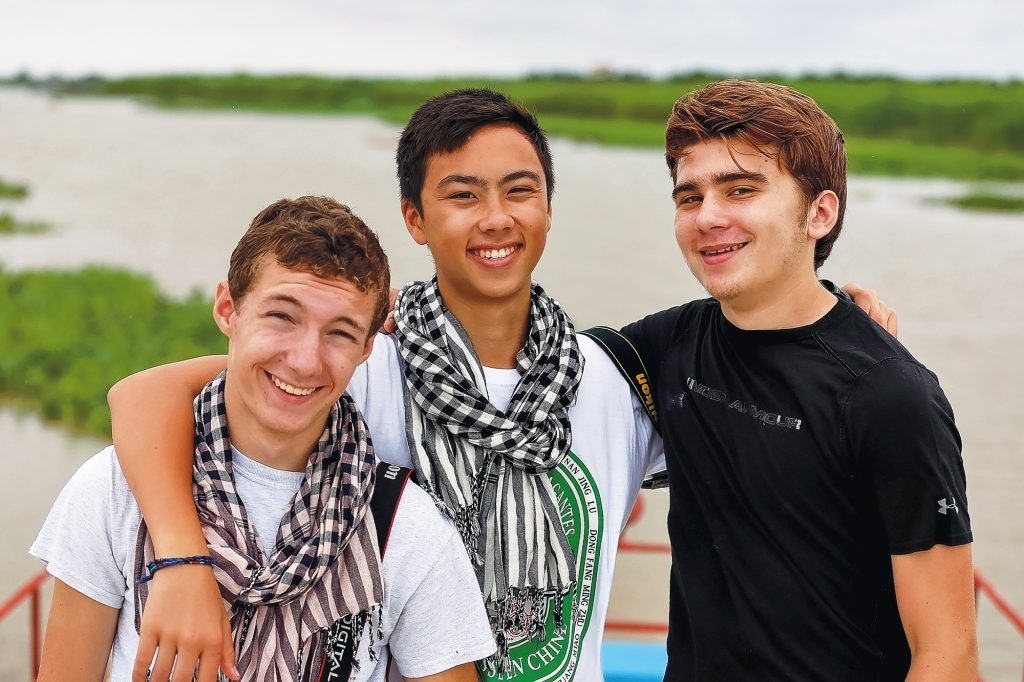 Rustic Pathways teen travelers on a boat during a summer program in Cambodia for high school students.