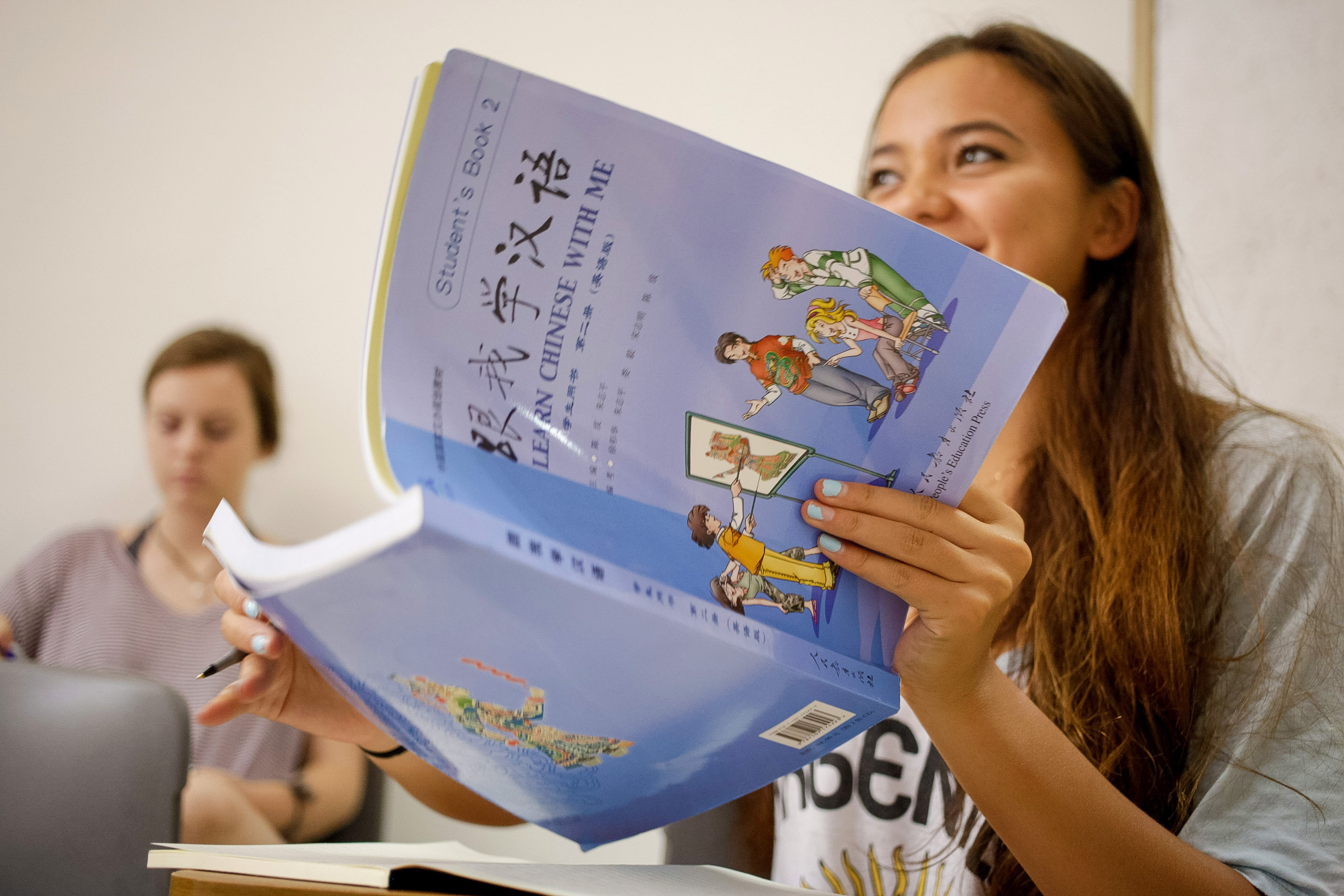 A student holds up a Mandarin textbook during class