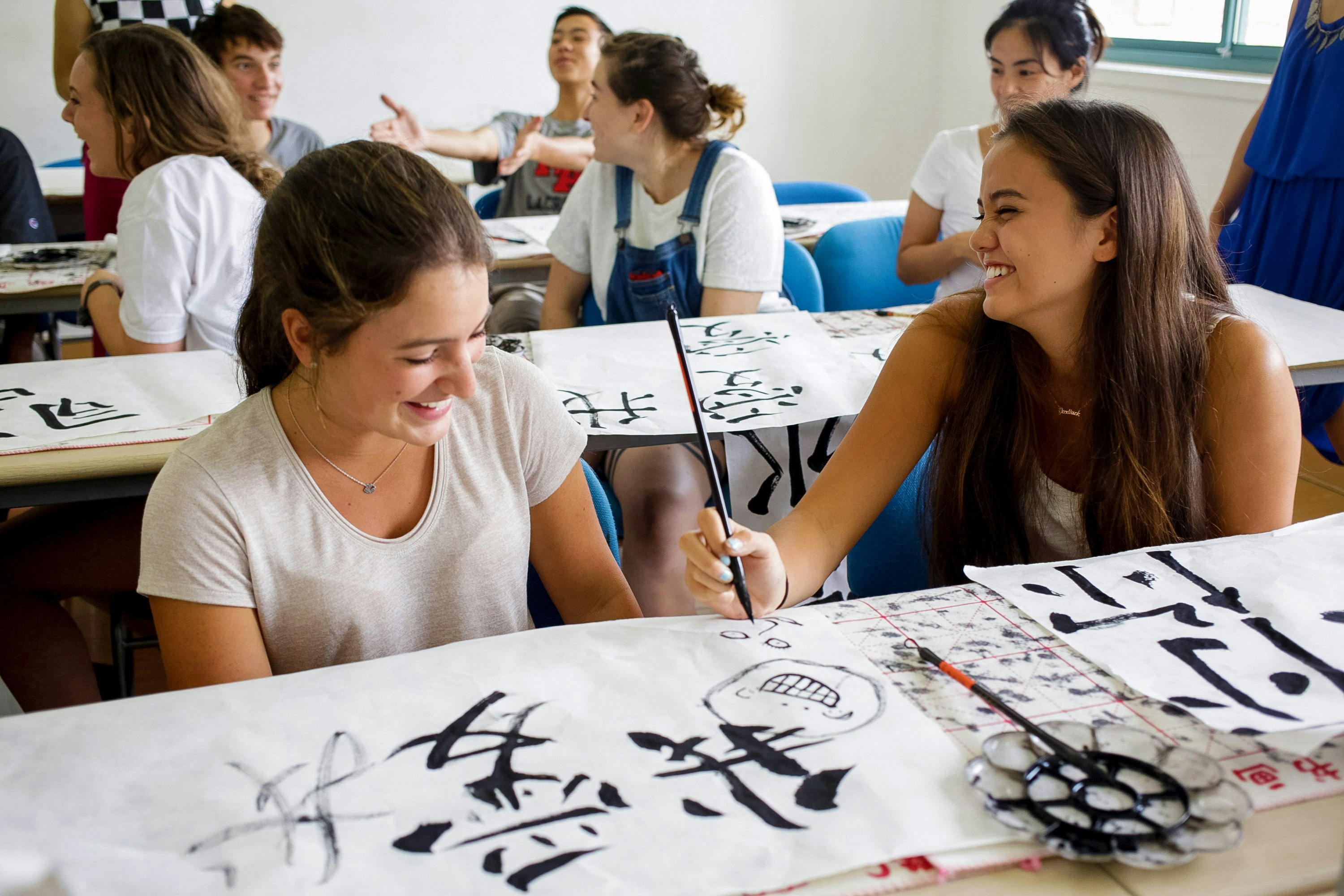 Students practicing Chinese calligraphy in a classroom in China.