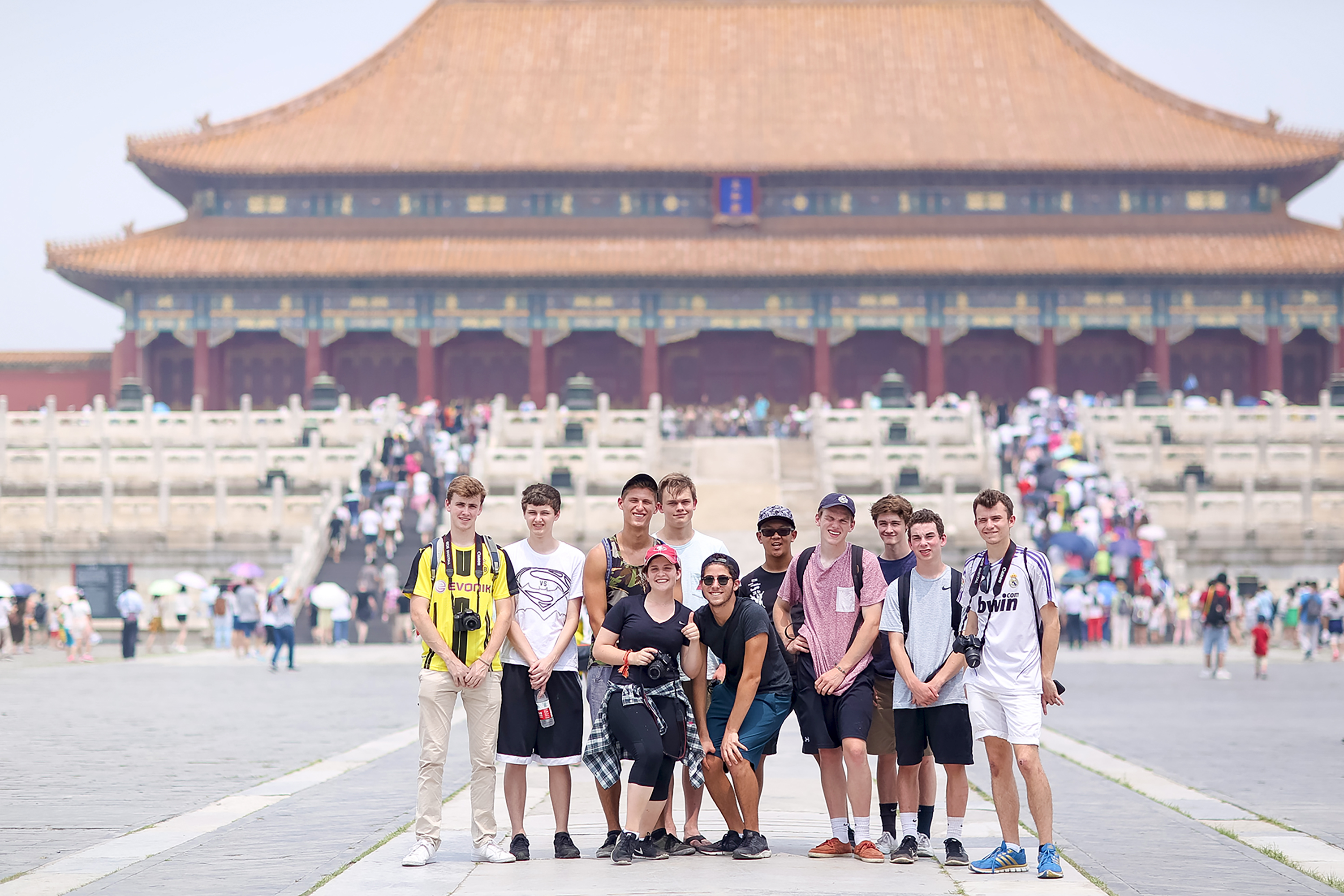Teen travelers in China pose together in front of the Forbidden City in Beijing