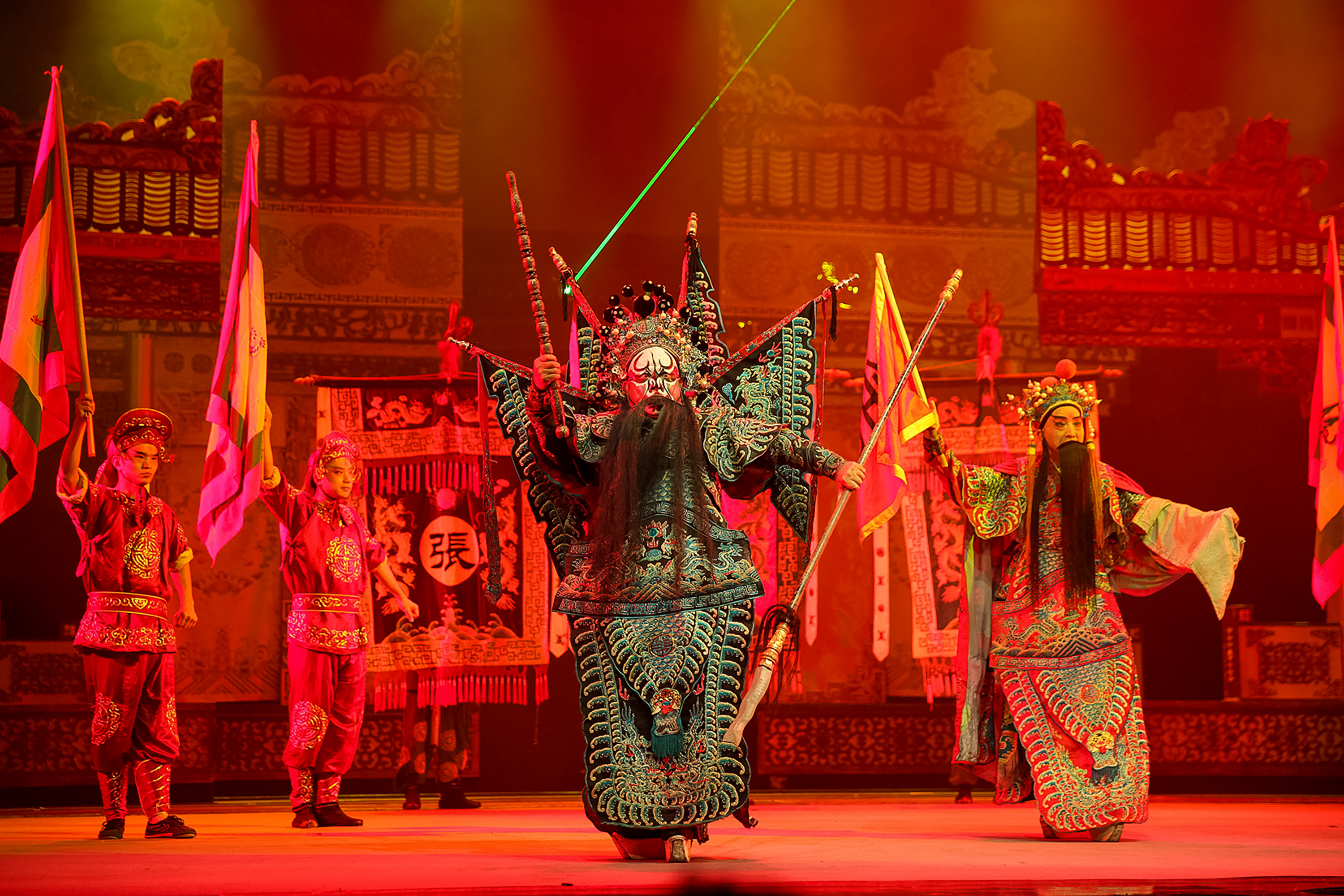 Performers in elaborate costumes and face paint act out a traditional Chinese opera on stage