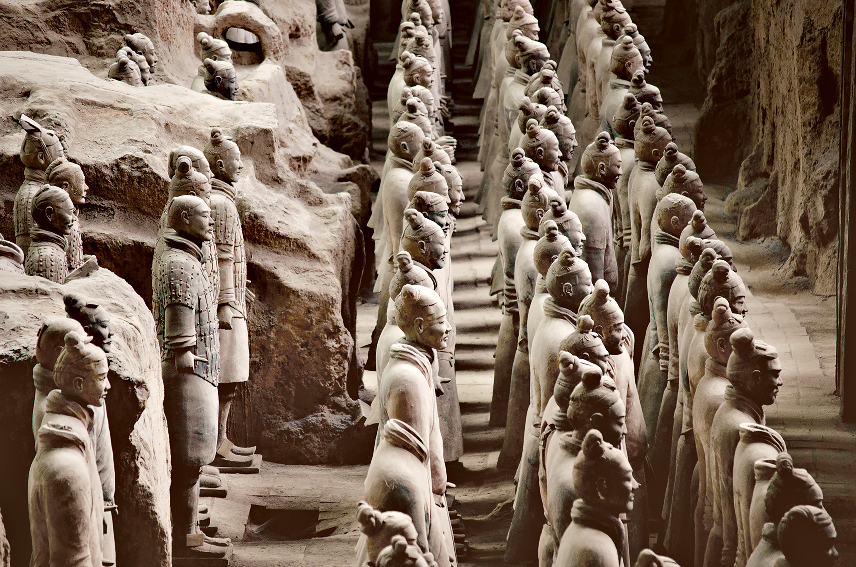 Rows of terracotta warrior statues stand in an excavated pit