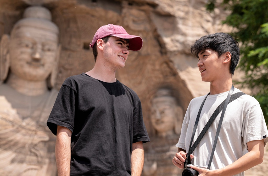 Students discussing lesson plans at a cultural site on a teaching volunteer abroad program.