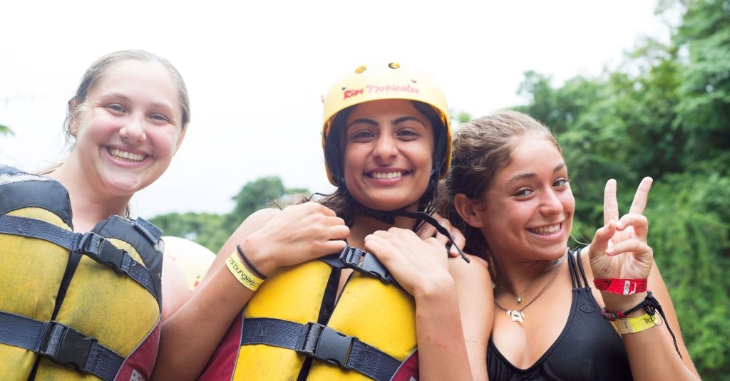Three girls on a teen travel program in Thailand preparing to go rafting.