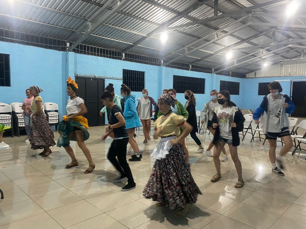 Students learn a traditional dance from locals.