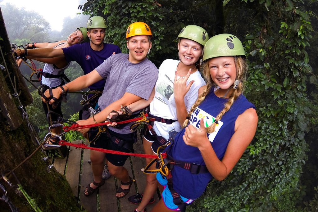 Rustic Pathways students pose during a zip line activity on a teen tour in Costa Rica