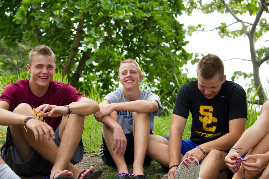 Group of students laughing together during a reflection session on their childcare volunteering abroad experience.