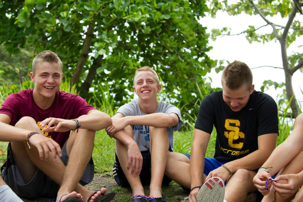 Teens relaxing together outdoors during a school group volunteer abroad programs service trip.