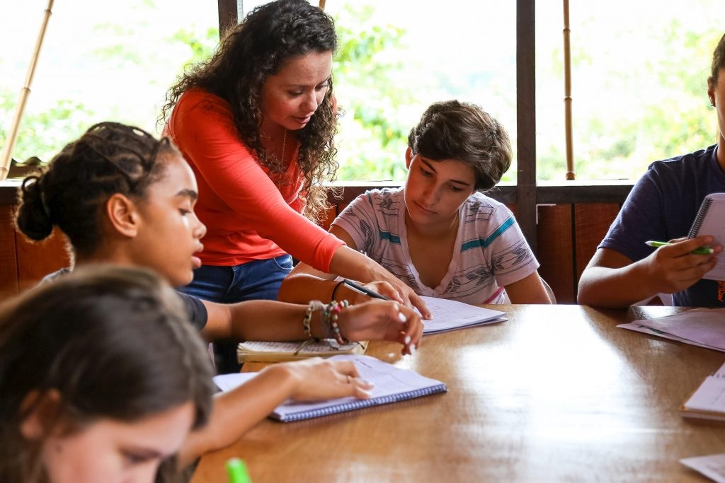 A teacher helping a student with their work in a classroom in Costa Rica.