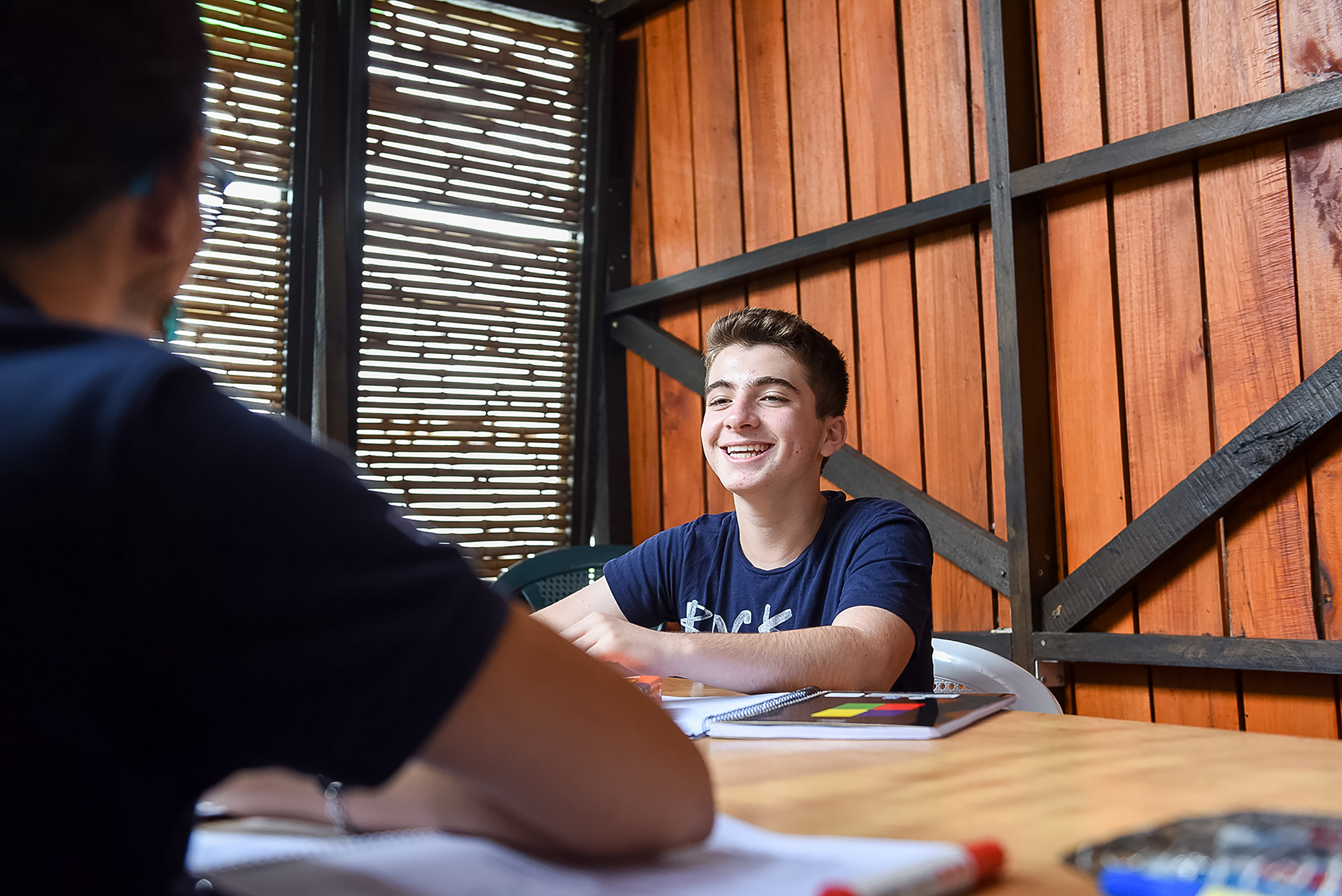 Student working through a workbook with an instructor at a wooden table