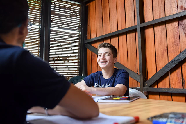 A student smiles across a desk during a Spanish class in Costa Rica