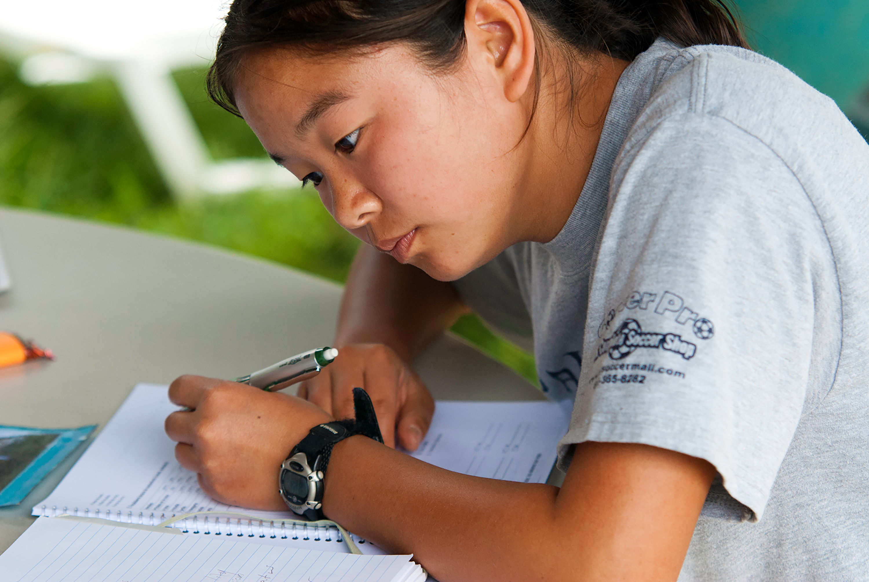 Student writing in a notebook during class