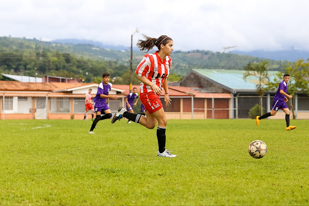 Girl playing in a soccer match supported by volunteers through a sports coaching volunteering abroad initiative.