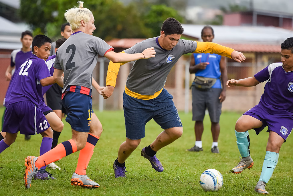 Volunteers coaching children during a soccer training session as part of a sports coaching volunteering abroad program.