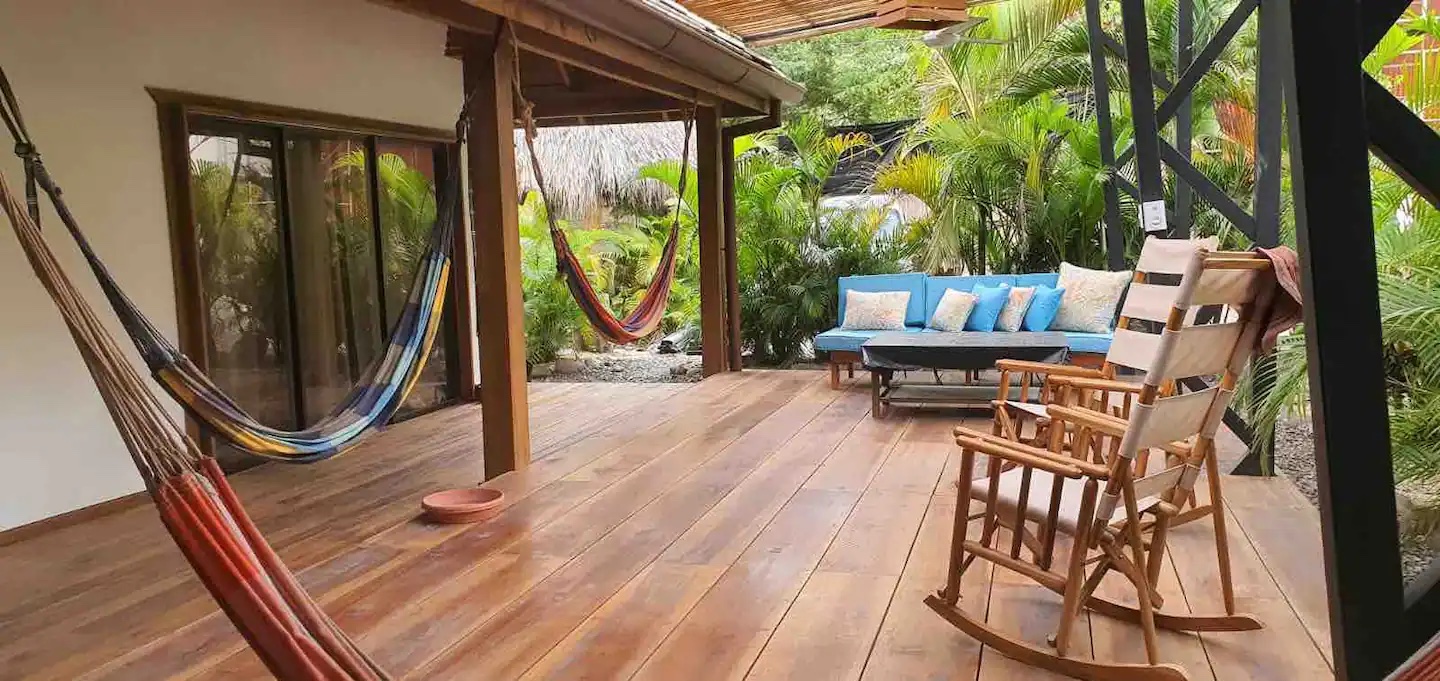 Picture of a bungalow with hammocks, chairs, and a couch.