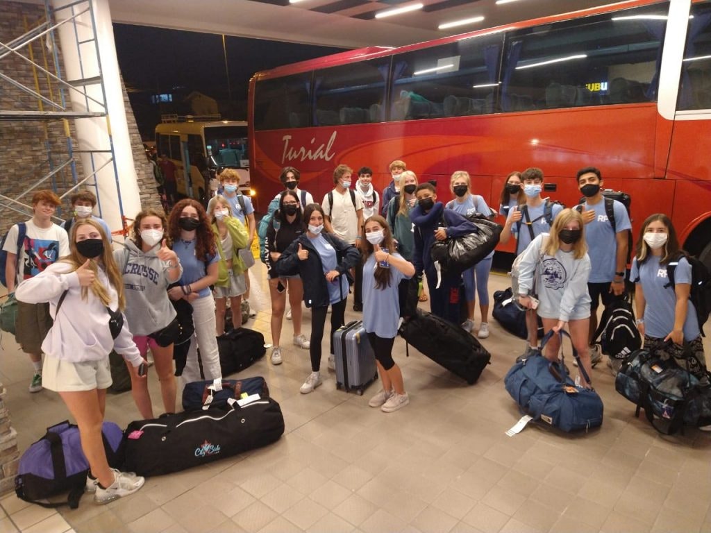 Rustic Pathways students arriving in Costa Rica gather with their bags as they wait to board the bus. 