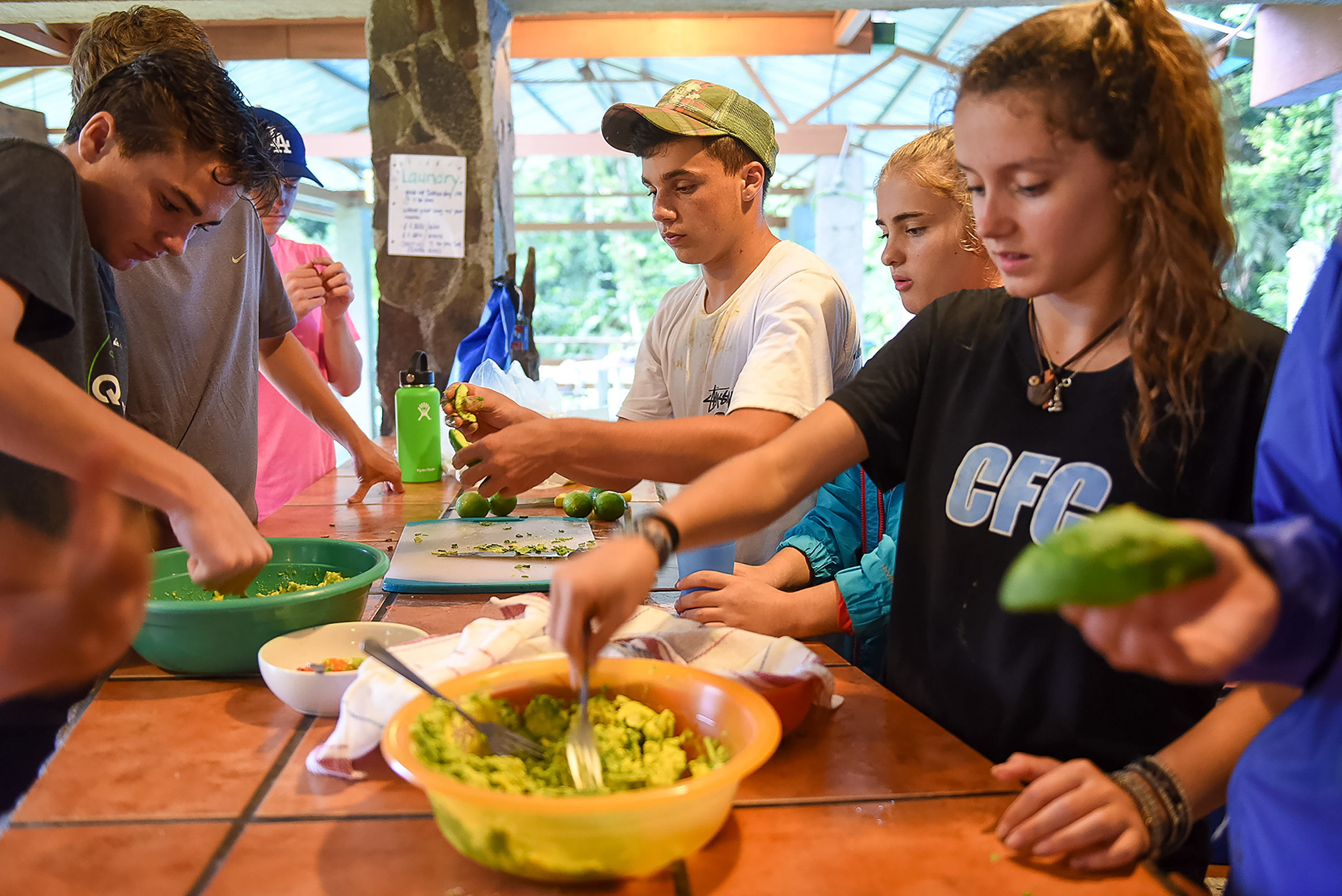 Students prepare guacamole together at an outdoor table