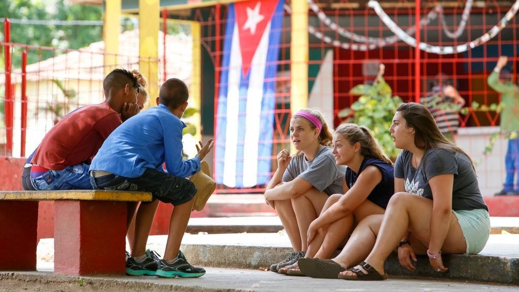 Rustic Pathways teen travelers talking to locals during a summer program in Cuba for high school students.