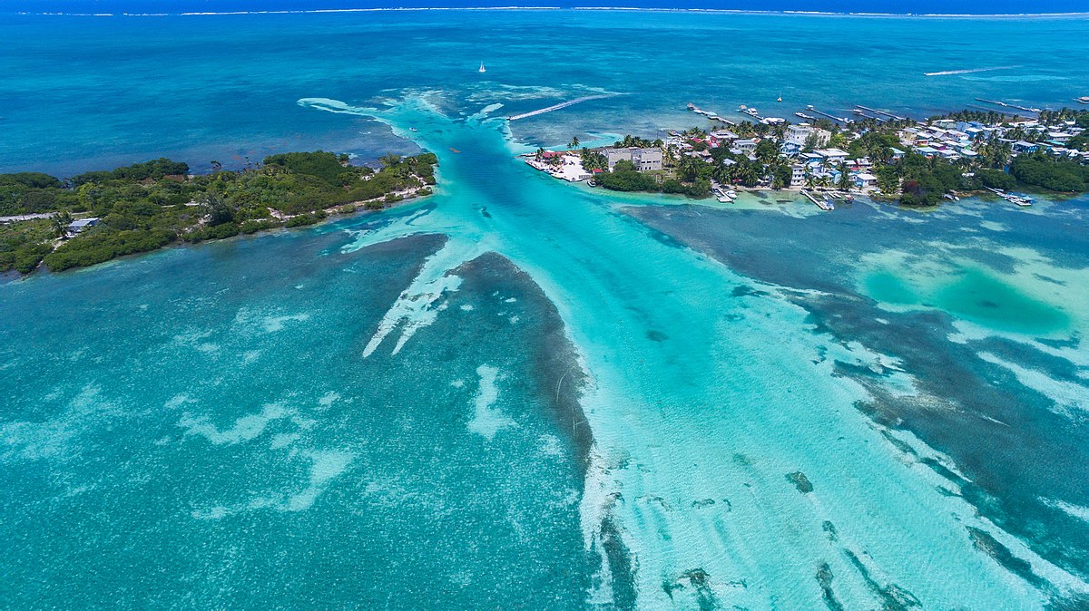 An aerial view of Caye Caulker in Belize, the island cut in two by a narrow channel of turquoise water.