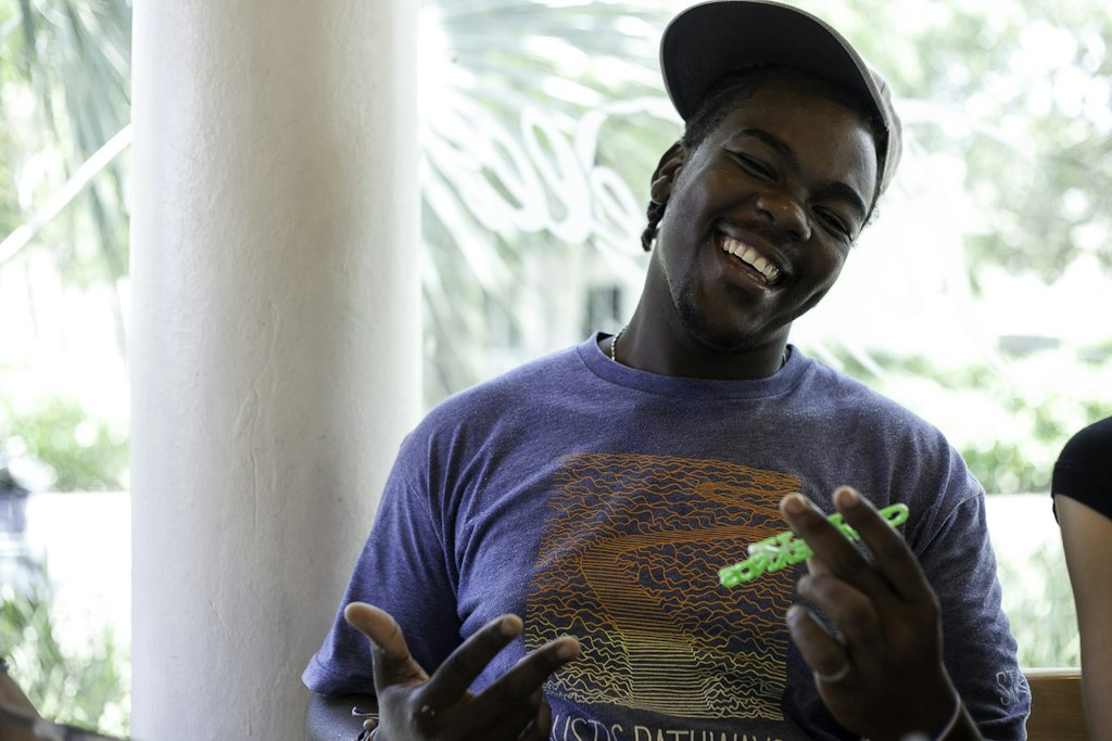 Smiling student wearing a Rustic Pathways shirt during a long-term volunteer abroad program, enjoying community time with peers.