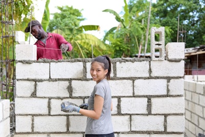 Student building a wall during a community service project on a Dominican Republic teen tour.
