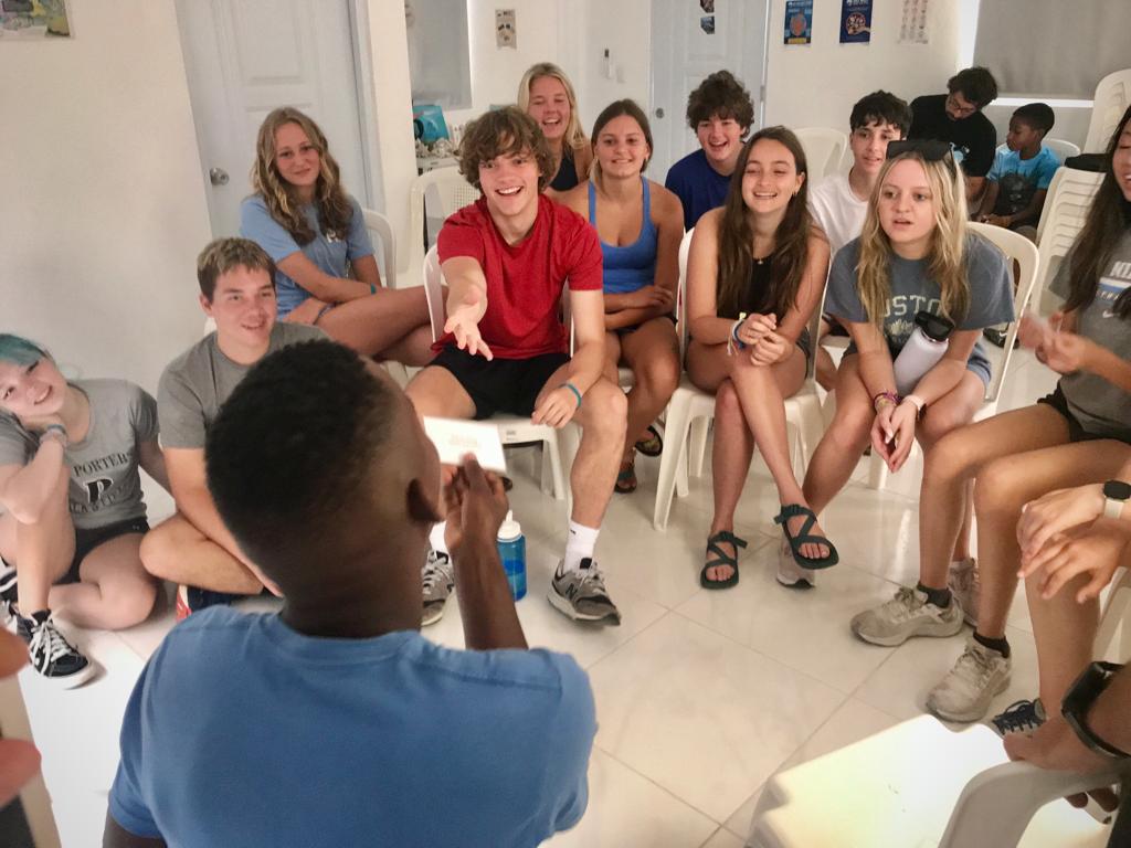 Students sit in a circle indoors during a group discussion