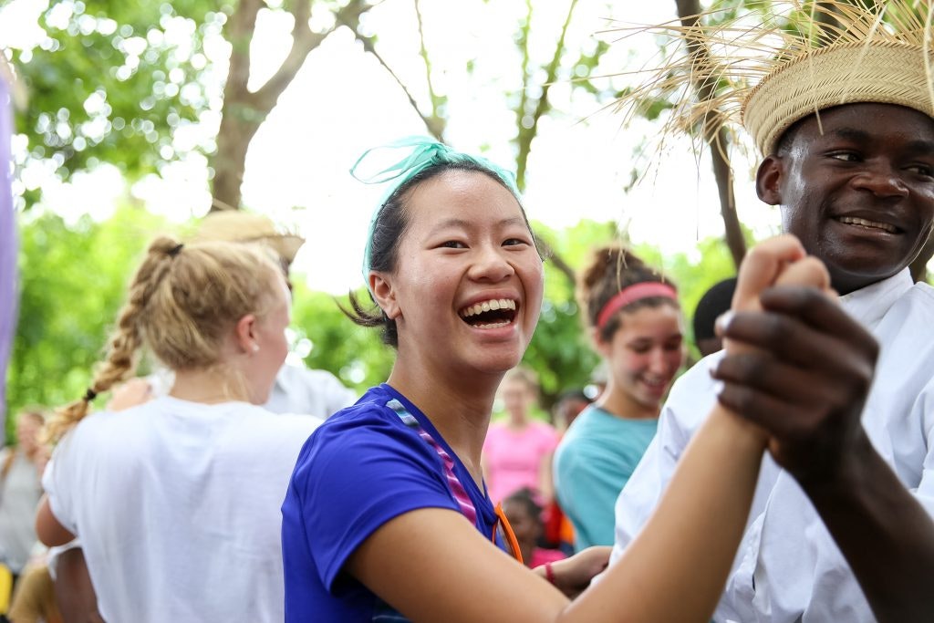 Teen traveler dancing with a local during a cultural exchange activity on a Dominican Republic teen tour.