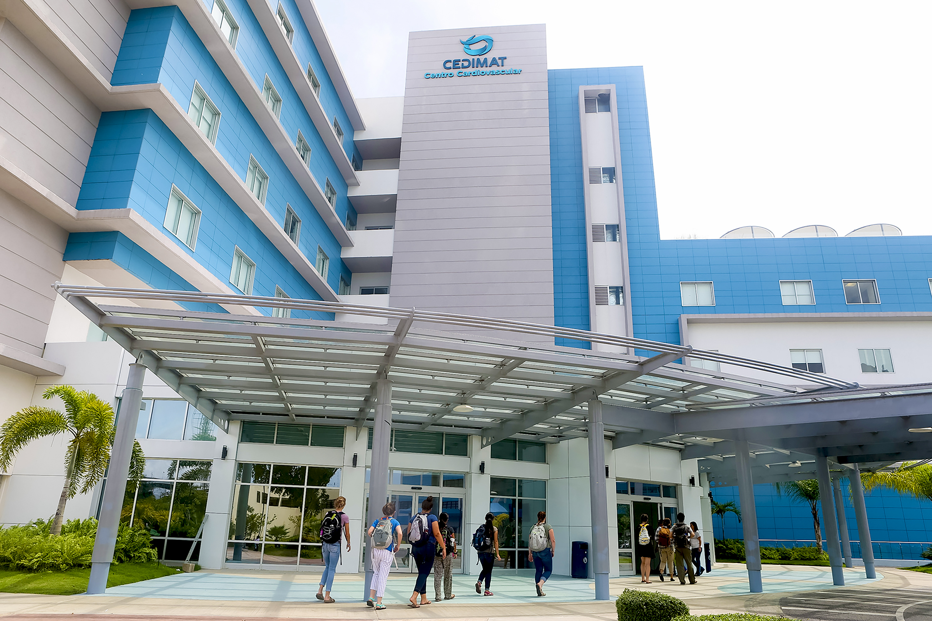 Students walk toward the entrance of the CEDIMAT hospital building