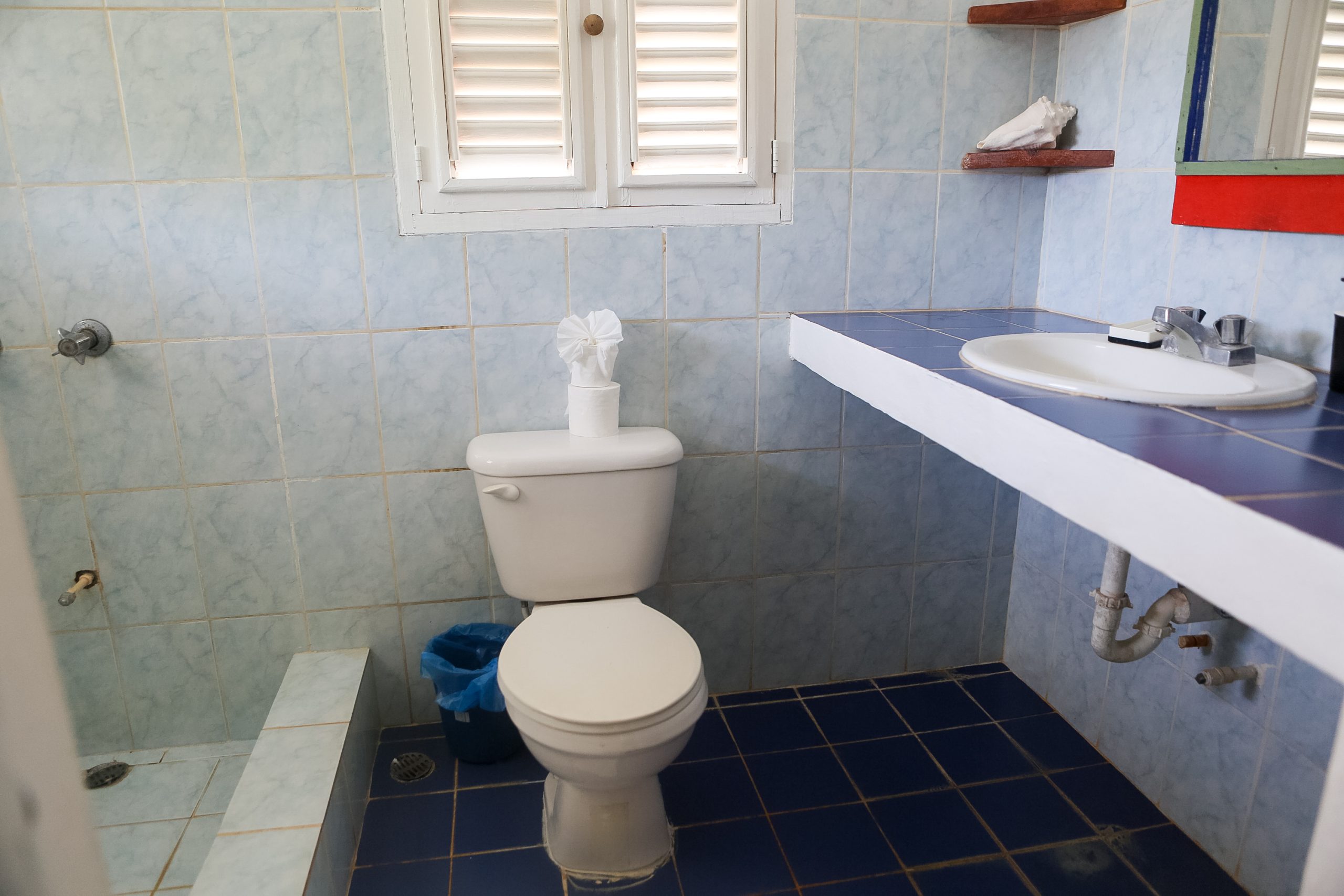 Modern bathroom with western toilet and clean tile floors at a base house in the Dominican Republic.