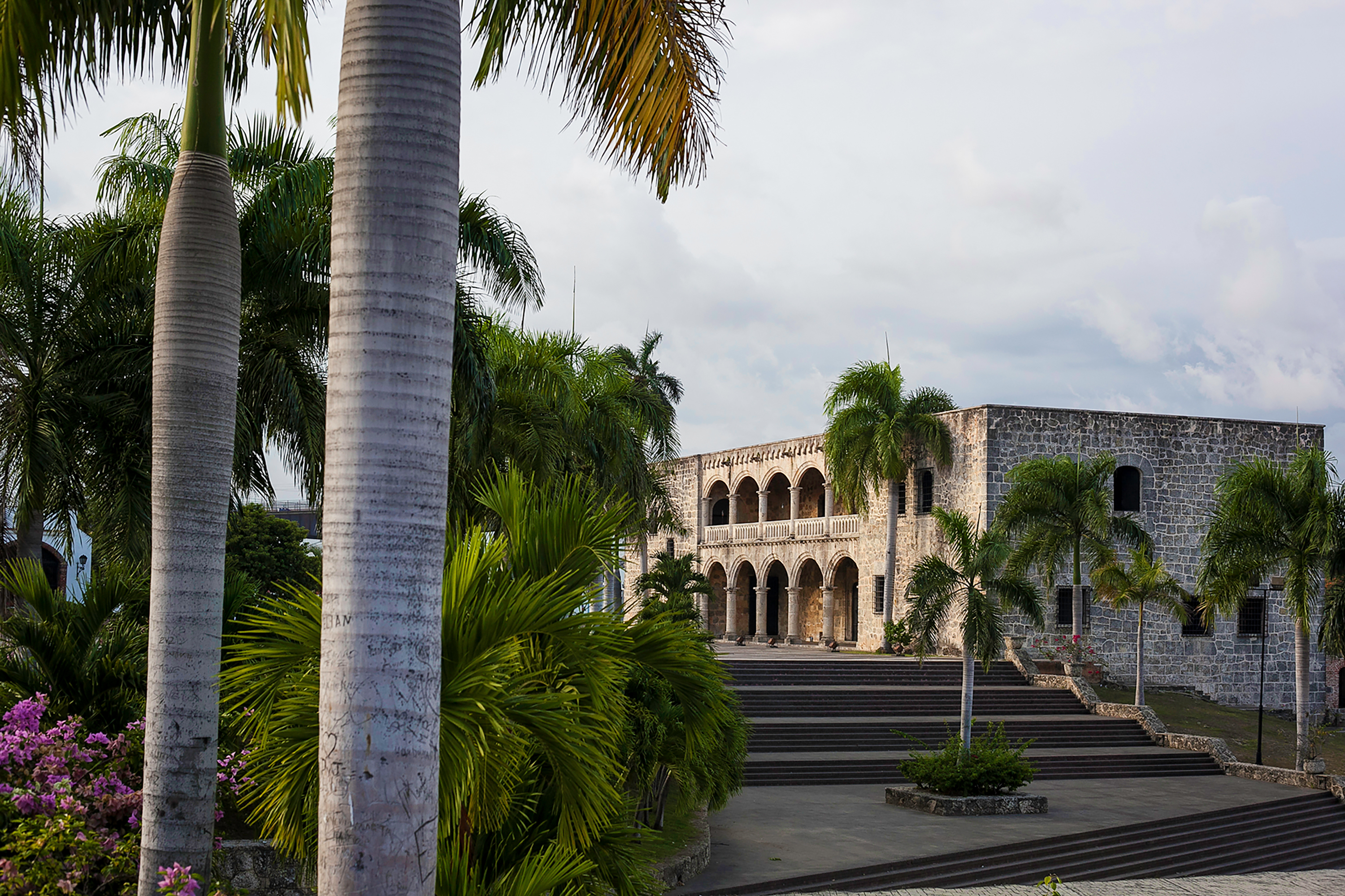 Palm trees frame a colonial stone building in Santo Domingo