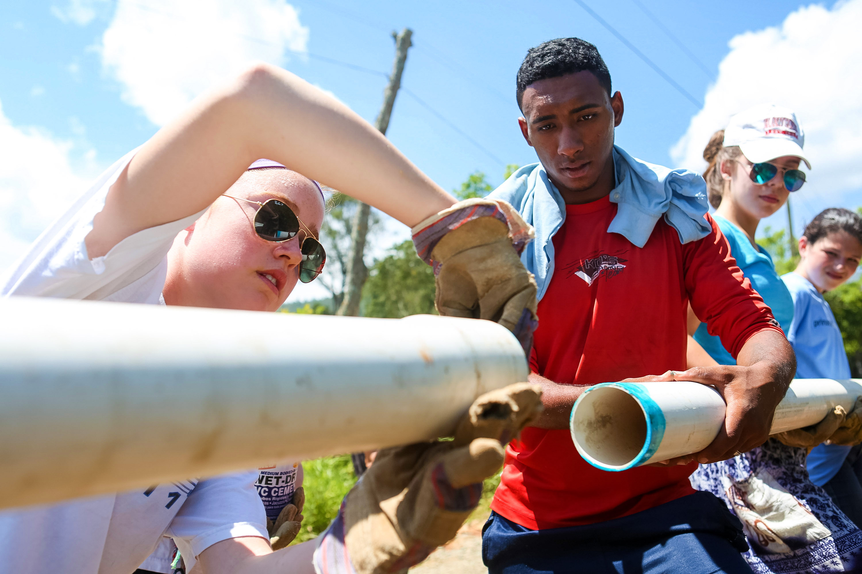 Students fit sections of PVC pipe together during a water infrastructure project