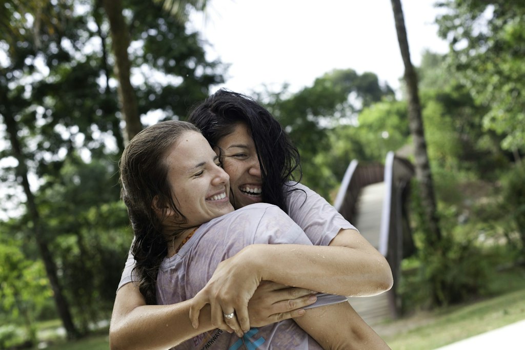 Two students sharing a joyful hug after community service during their first-time volunteer abroad trip with Rustic Pathways