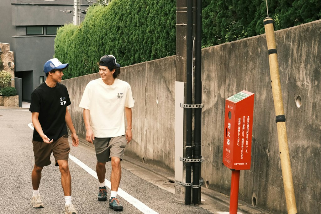Two students walking and talking in a Japanese neighborhood during a Rustic Pathways ethical volunteering abroad program promoting cultural respect and responsible travel.