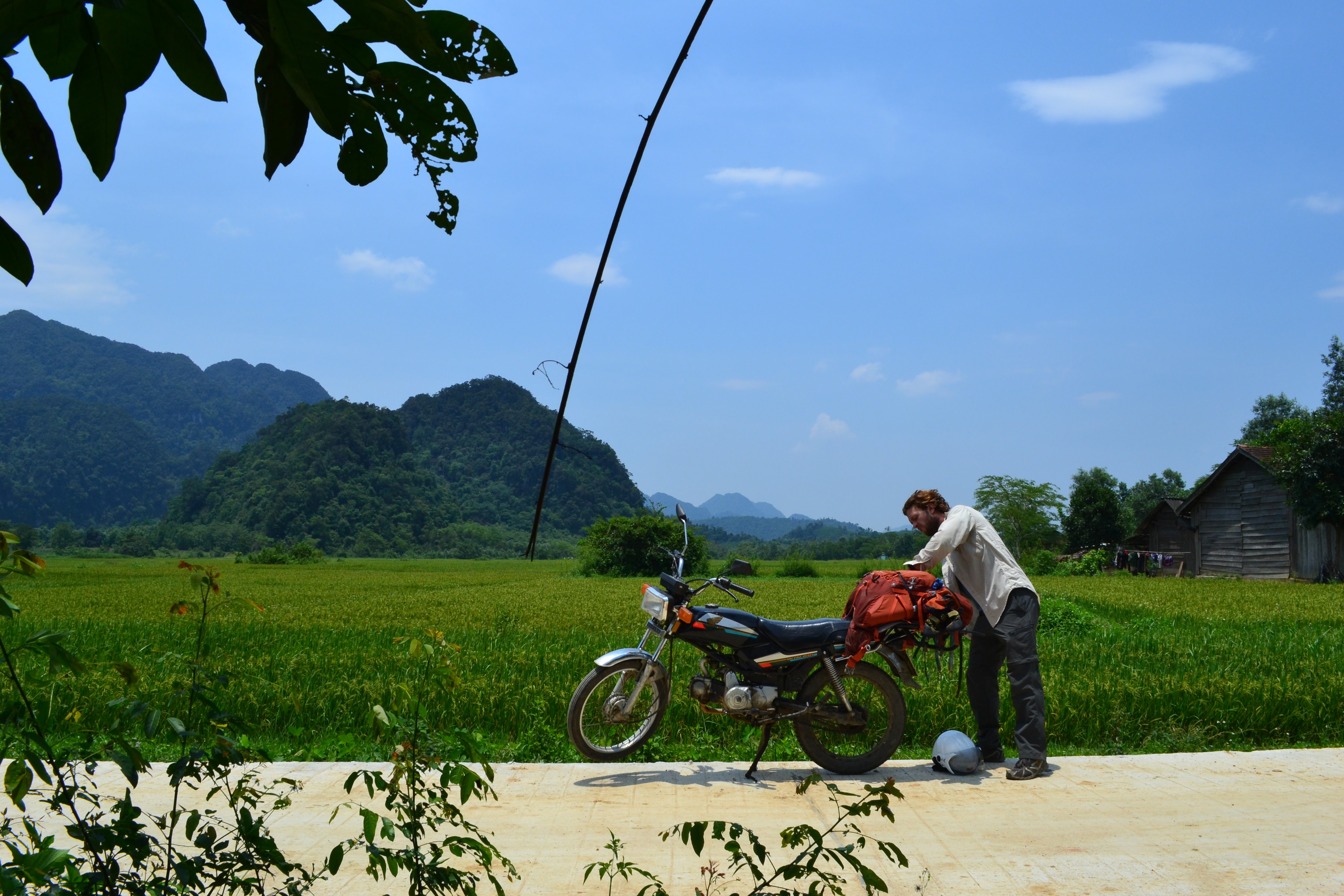 Traveler preparing a motorbike for a journey through Vietnam’s scenic countryside.