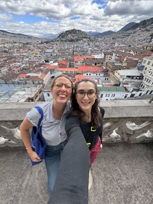Two female students pose for a photo overlooking Quito, Ecuador, on a teen tour in the Americas.